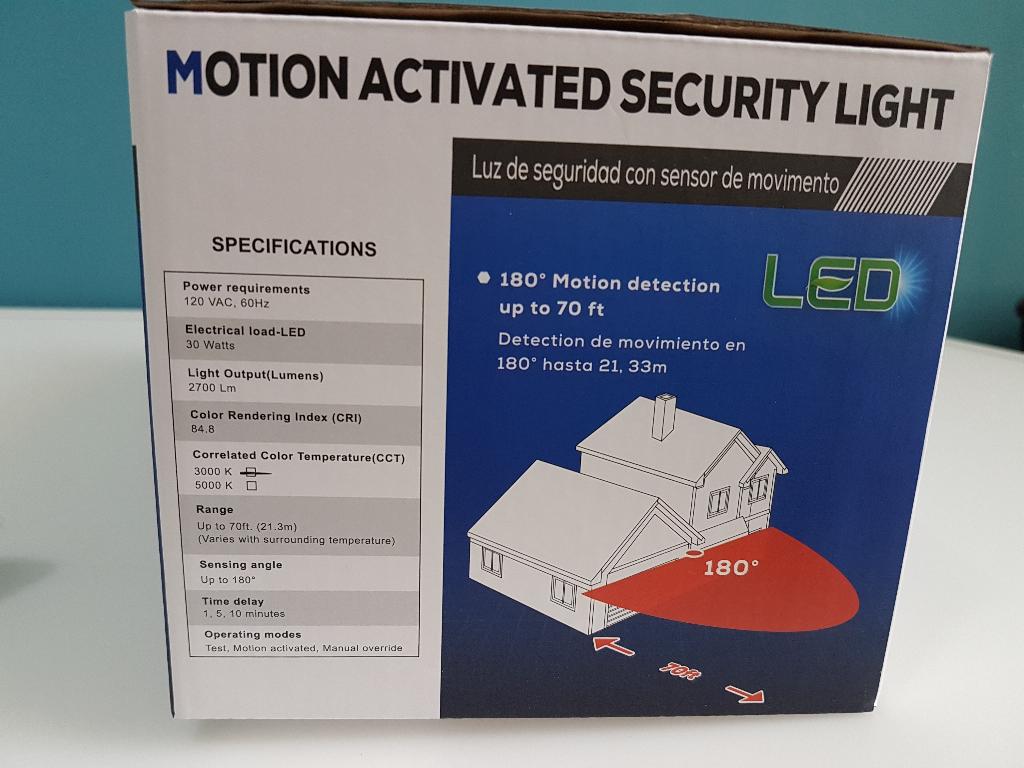 The retail packaging box for a motion-activated LED security light, featuring specifications and product details on a white and blue background with a house illustration.
